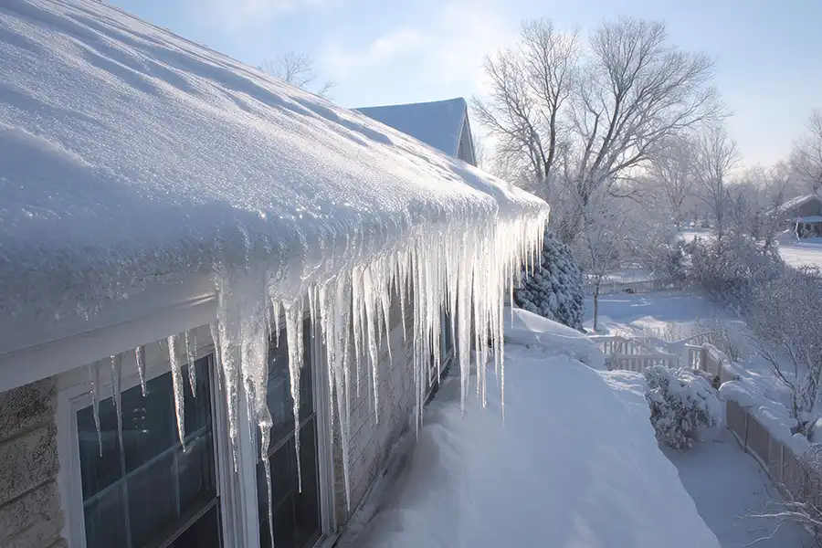 Roller Brothers Construction—Preventing ice dams on a roof in a snowy residential area during the winter season in Springfield, IL.